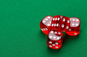 group of red dice on a green table are in a casino