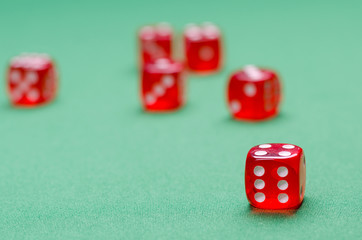 group of red dice on a green table are in a casino