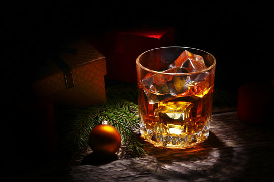 Glass With Cognac Or Whiskey, Christmas Balls And Candles. New Year's Tree, Balls And Glass With Alcohol.