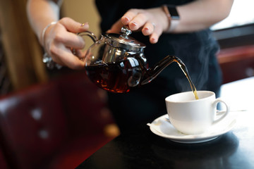 Waiter fills cup of tea