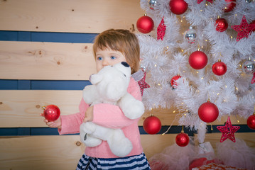Fototapeta na wymiar Little girl in christmas home interior. Blue-eyed Girl with a favorite toy in Christmas. gift from Santa Claus 