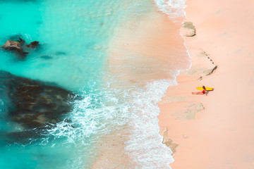 Woman surfing at wild tropical beach