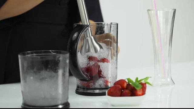 making straberry smoothie with hand blender