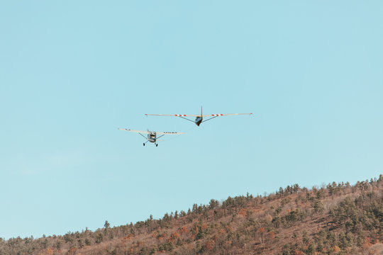 Propeller plane towing a glider into flight