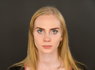 Caucasian white female model portrait. Beautiful girl, long blonde hair. Woman posing studio shot on a black background
