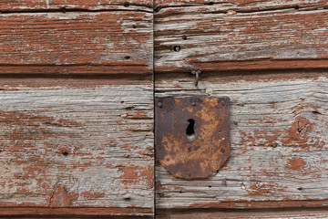 Old rusty metal keyhole on old brown wooden door. Rusty keyhole.