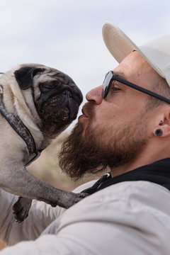 Man kissing little pug