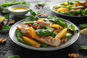 Grilled chicken with orange and avocado salad on rustic background