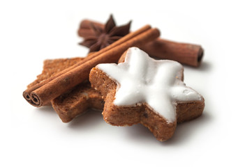 closeup of christmas biscuit shaped star with anise flower and cinnamon stick on white background