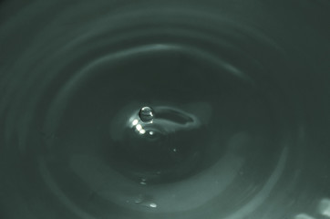 Photograph of a drop of water falling into a bucket full of water