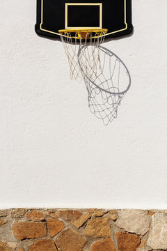 Basketball ring on white sunny wall