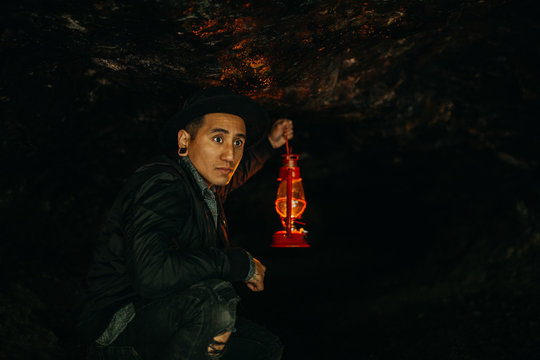 Man Holding Lantern In Cave