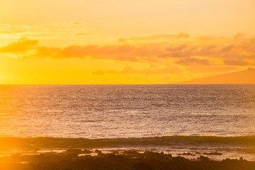 beautiful sunset with coast and ocean. tropical place with island in background and  waves. relax and quiet vacation leisure concept with sunset colors and stop work mood. enjoy the nature and travel