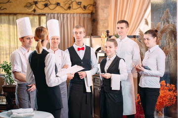 restaurant manager and his staff in kitchen. interacting to head chef in commercial kitchen.