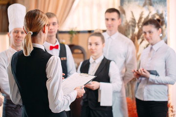 restaurant manager and his staff in kitchen. interacting to head chef in commercial kitchen.