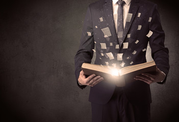Man holding a book with document symbols around.