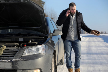 Man stands outdoor near broken car