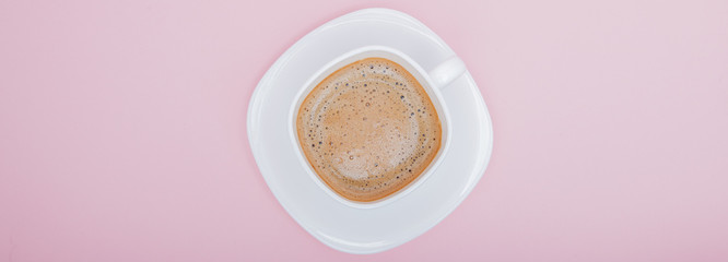 white mug with coffee on a pink background, copy space