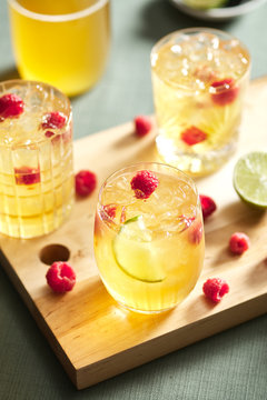 Fermented tea with raspberry and lime on wooden board.