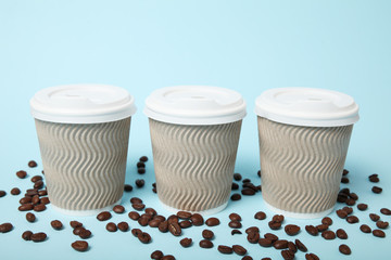 Cardboard takeaway cup and coffee beans.