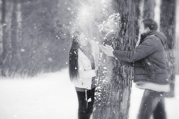 A loving couple on a winter walk. Man and woman on a date in the park in winter. Friends in a winter park