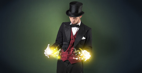 Magician holding his sparkling power between his two hand