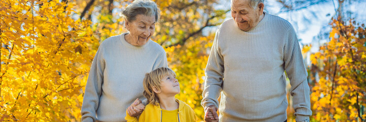Senior couple with baby grandson in the autumn park. Great-grandmother, great-grandfather and...