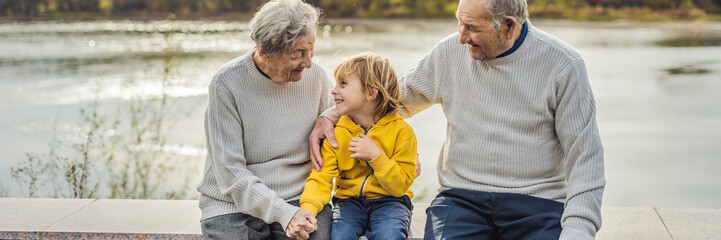 Senior couple with baby grandson in the autumn park. Great-grandmother, great-grandfather and...