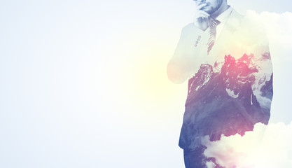 Businessman standing and thinking with snowy mountain graphic
