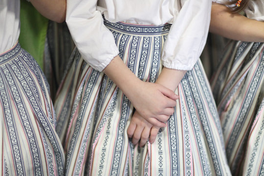 The hands of a girl in an ethnographic costume from a folklore dance group