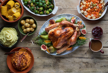 Turkey dinner and side dishes on a wood background.