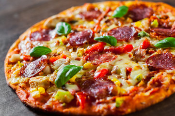 Pizza with Chicken meat, Mozzarella cheese, pepperoni, tomato, vegetables, salami. Italian pizza on wooden background