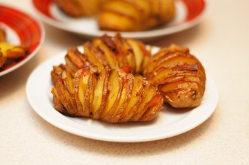 Baked potatoes with cheese and lard with onions are cooked at home on a plate