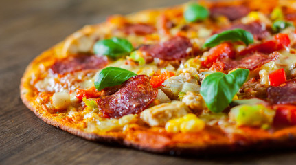 Pizza with Chicken meat, Mozzarella cheese, pepperoni, tomato, vegetables, salami. Italian pizza on wooden background