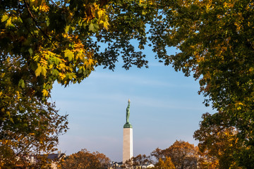 Monument of Freedom. Riga, Latvia. Woman personified Latvia holds three gold stars - tree...