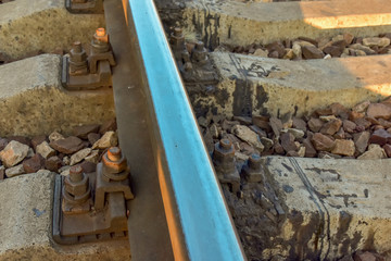 Fototapeta na wymiar Railroad Train Tracks with Concrete Sleepers and Stones, Metal Rails Close Up View.