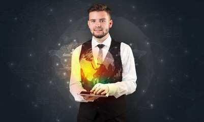 Spectacled businessman with global hologram concept and tablet on his hand
