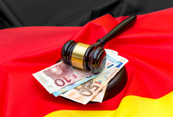 Gavel with euro bills on German flag.