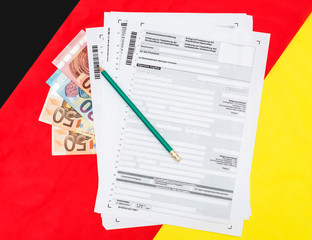 German tax form with euro bills on flag. 