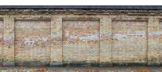 Old spotty yellow brick  aged  fence long fragment  isolated on top