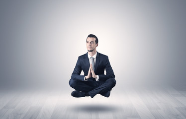 Businessman levitates and sitting in yoga position in an empty infinity space

