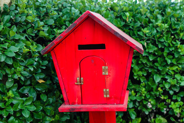 red house mailbox on a green background of nature