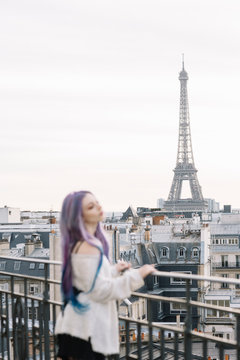 Young woman on a balcony with the Eiffel tower view