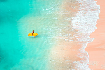 Woman surfing at wild tropical beach