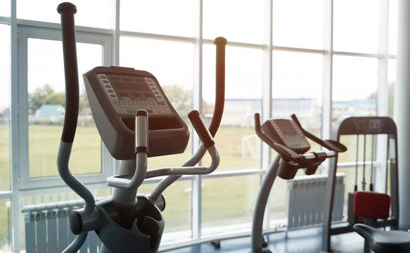 Row of elliptical trainers in big new gym at angle