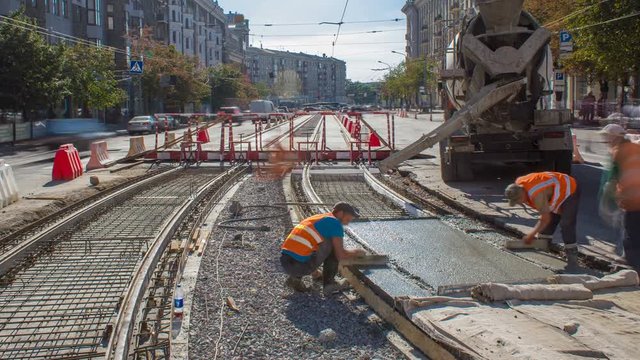 Concrete works for road maintenance construction with many workers and mixer timelapse