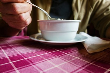 Man eat soup at table.