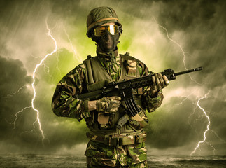 Armed soldier standing in rainy obscure weather
