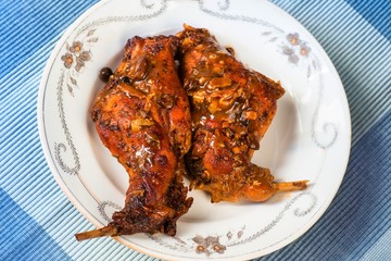 2 baked rabbit thigs on plate.