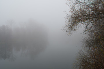 Obraz na płótnie Canvas Foggy condition of the autumn November weather on the river